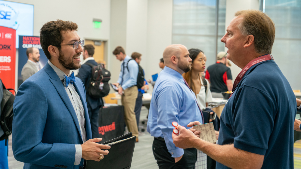 A student chats with a hiring manager at a Nuclear Security Enterprise Day career fair.
