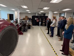 Roughly 17 people standing inside of the High Velocity Impact Laboratory on the Texas A&M-RELLIS campus.