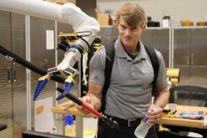 Photo of Dr. Marv Adams interacting with a robotic arm at the RAD Lab.